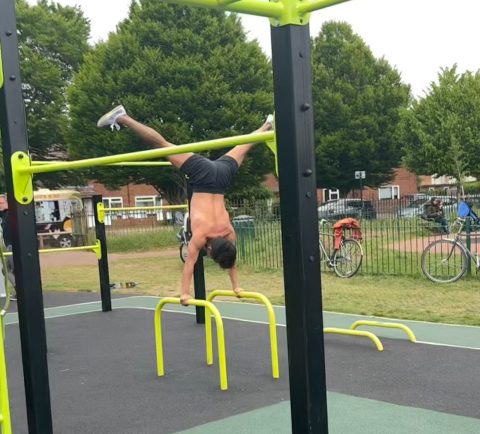 Person performing calisthenics on outdoor gym equipment